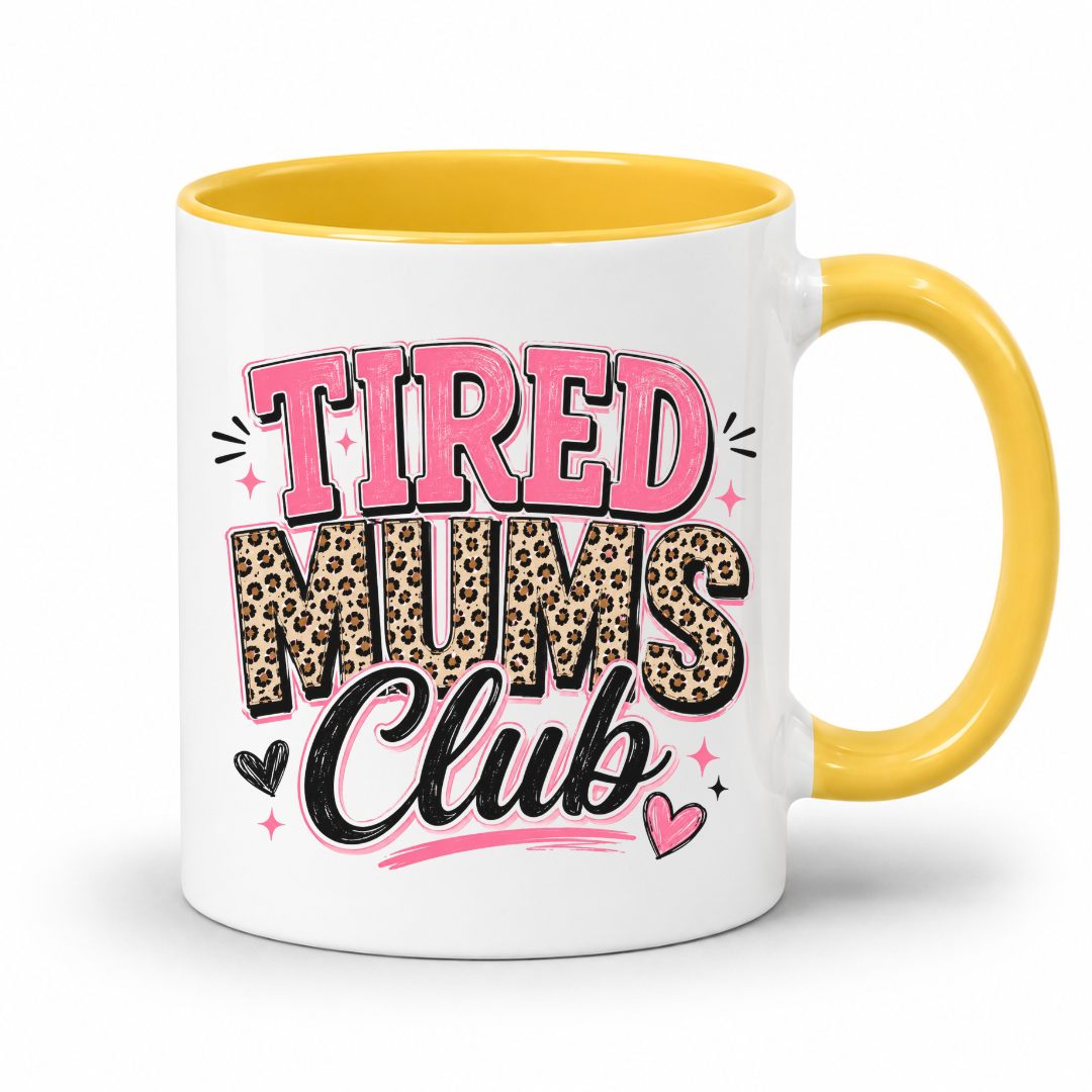 A white ceramic mug with a yellow interior and handle, featuring the text 'TIRED MUMS Club' in pink, leopard print, and black lettering on the front. Grab your mug from Coffee and Moo NZ.