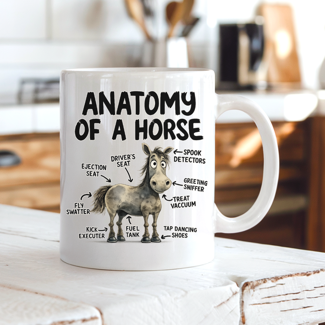 A white ceramic mug with a humorous 'Anatomy of a Horse' graphic, sitting on a rustic white wooden surface with a blurred kitchen background. From Coffee and Moo NZ.