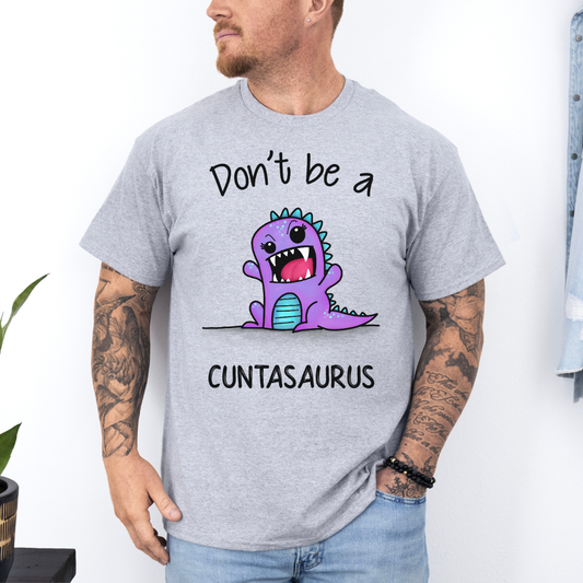 A man wearing a grey graphic t-shirt with a cartoon purple dinosaur and the text 'Don't be a CUNTASaurus'. Purchase from Coffee and Moo NZ.