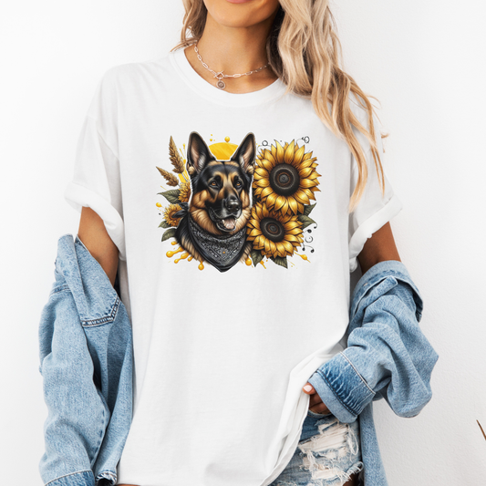 A man wearing a white short-sleeve t-shirt with a graphic print of a German Shepherd dog surrounded by yellow sunflowers, paired with light blue jeans. Grab your tee from Coffee and Moo NZ.