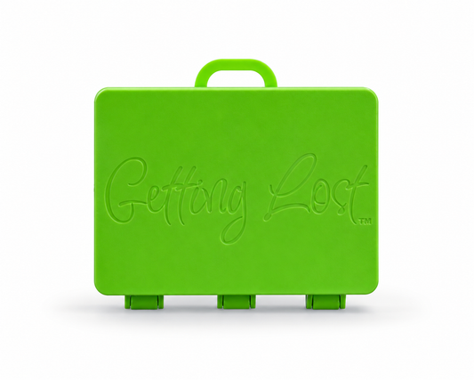 A green rectangular carrying case with a top handle, featuring the words 'Getting Lost' embossed on the front, set against a plain white background. For the Getting lost card game. Purchase from Coffee and Moo