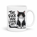 A white ceramic mug featuring a black and white cat illustration and the text 'THE FUCK YOU LOOKING AT?' in a bold black font, set against a plain white background. From Coffee and Moo
