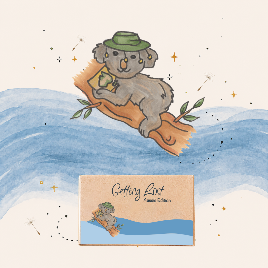 Illustration of a koala on a log with a hat, set against a watercolor landscape with 'Getting Lost' text. Getting Lost Aussie Edition Adventure Card Game. Purchase yours from Coffee and Moo NZ.