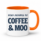 A white ceramic coffee mug with a bright orange handle and interior, featuring the text 'HERD MEMBER OF COFFEE & MOO' printed in dark navy blue on the front, set against a plain white background. Grab your mug from Coffee and Moo NZ.