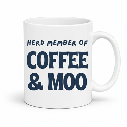 A white ceramic coffee mug with the text 'HERD MEMBER OF COFFEE & MOO' printed in dark navy blue, shown on a clean white background. Grab your mug from Coffee and Moo NZ.