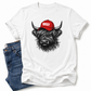 A white short-sleeve T-shirt laid flat with a graphic of a shaggy black-and-gray Highland cow wearing a red cap with the word 'BOSSY' in white. Blue jeans are partially visible underneath on the left side. Grab your bossy tee from Coffee and Moo NZ.