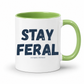 A white ceramic coffee mug with a light green interior and handle, featuring the text 'STAY FERAL' in dark navy blue with a small tagline underneath, on a clean white background. Grab your feral mug from Coffee and Moo NZ.