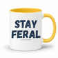 A white ceramic coffee mug with a yellow interior and yellow handle, featuring the text 'STAY FERAL' in dark navy blue letters and 'and slightly UNHINGED' in smaller text below, on a white background. Grab your feral mug from Coffee and Moo NZ.