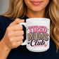 A woman holding a white ceramic mug with a graphic that reads 'TIRED MUMS Club' in pink, leopard print, and black lettering. Grab your mug from Coffee and Moo NZ.