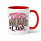 A white ceramic coffee mug with a red handle and red interior, featuring the text 'TIRED MUMS Club' in pink, leopard print, and black lettering. Grab your mug from Coffee and Moo NZ.