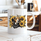 A white ceramic mug with a printed graphic of a beagle dog surrounded by yellow sunflowers and a black bandana, set on a rustic white wooden table with a blurred kitchen background. Grab your mug from Coffee and Moo NZ.