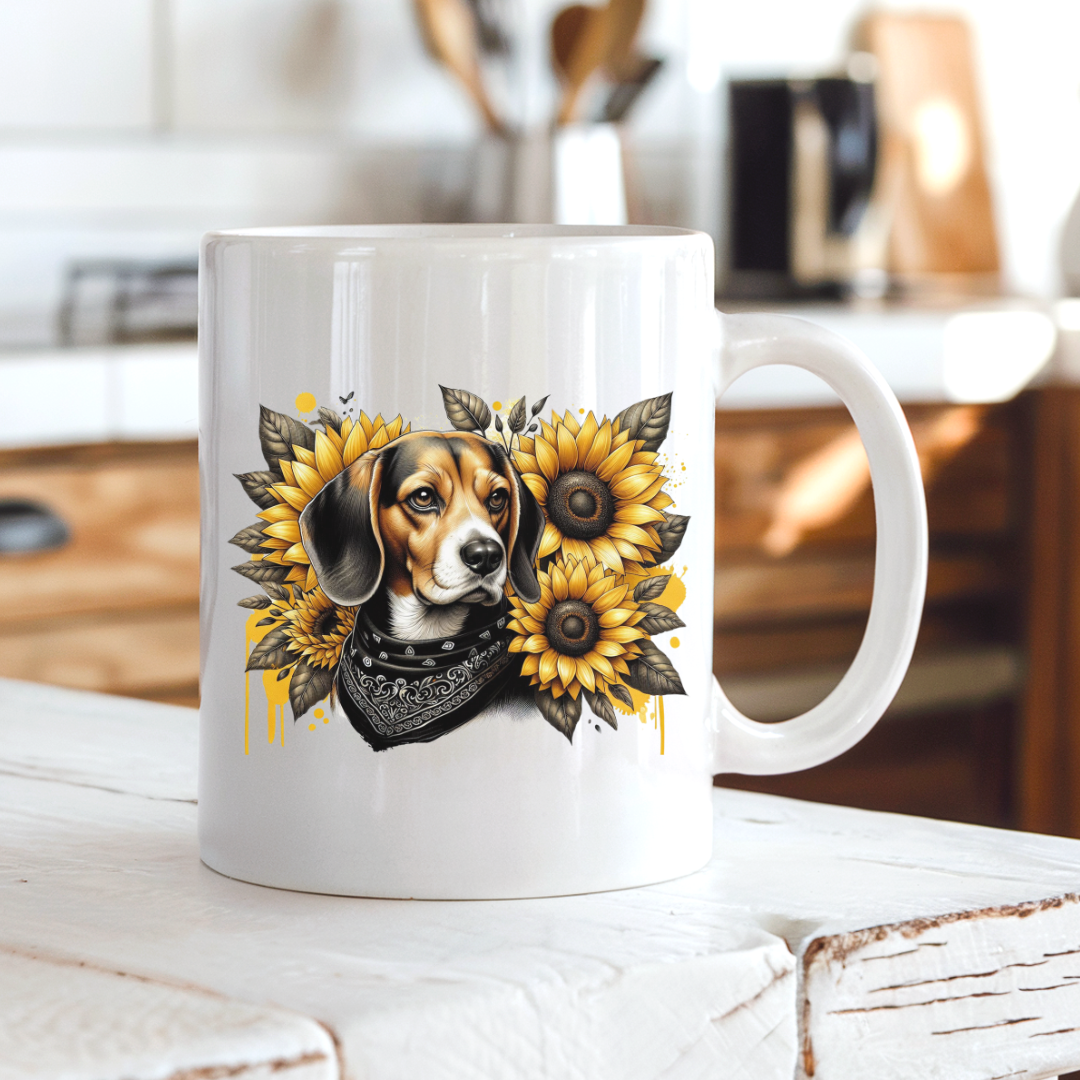 A white ceramic mug with a printed graphic of a beagle dog surrounded by yellow sunflowers and a black bandana, set on a rustic white wooden table with a blurred kitchen background. Grab your mug from Coffee and Moo NZ.