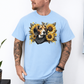 A man wearing a light blue crewneck t-shirt with a graphic print of a beagle dog surrounded by yellow sunflowers and a black bandana. Grab your tee from Coffee and Moo.