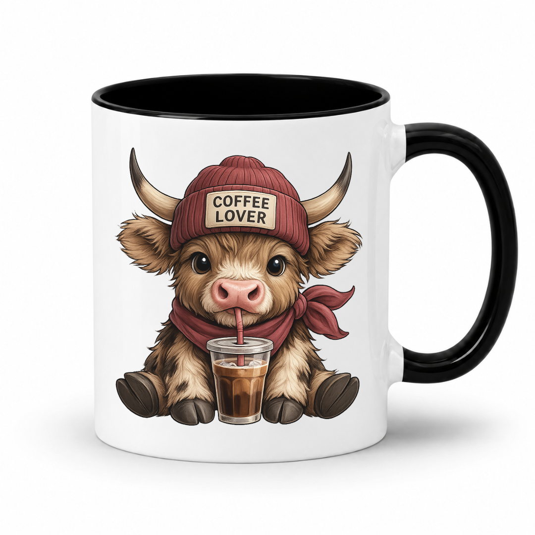 A white ceramic coffee mug with a black interior and handle, featuring a cartoon Highland cow wearing a red beanie that says 'COFFEE LOVER' and holding a drink. from Coffee and Moo.