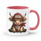 A white ceramic coffee mug with a pink interior, handle, and rim, featuring a cartoon illustration of a horned cow wearing a red beanie that says 'COFFEE LOVER' and holding a drink. from Coffee and Moo.