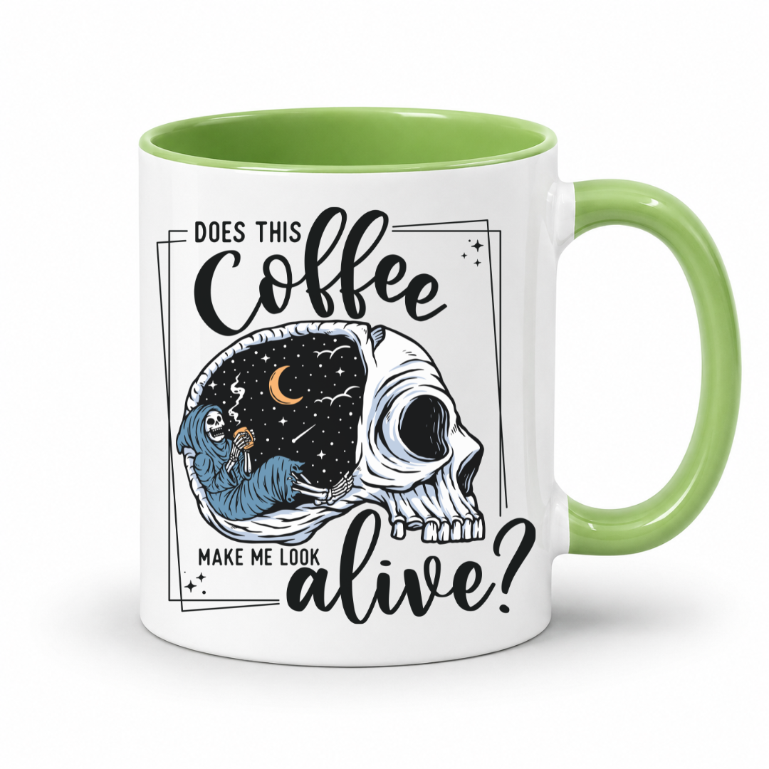 while mug with a green handle and inner with a graphic on it that features a skull with one half showing a starry night sky with a crescent moon and a skeleton holding a coffee, accompanied by the text 'DOES THIS Coffee MAKE ME LOOK alive?'. Grab yours from Coffee and Moo NZ.