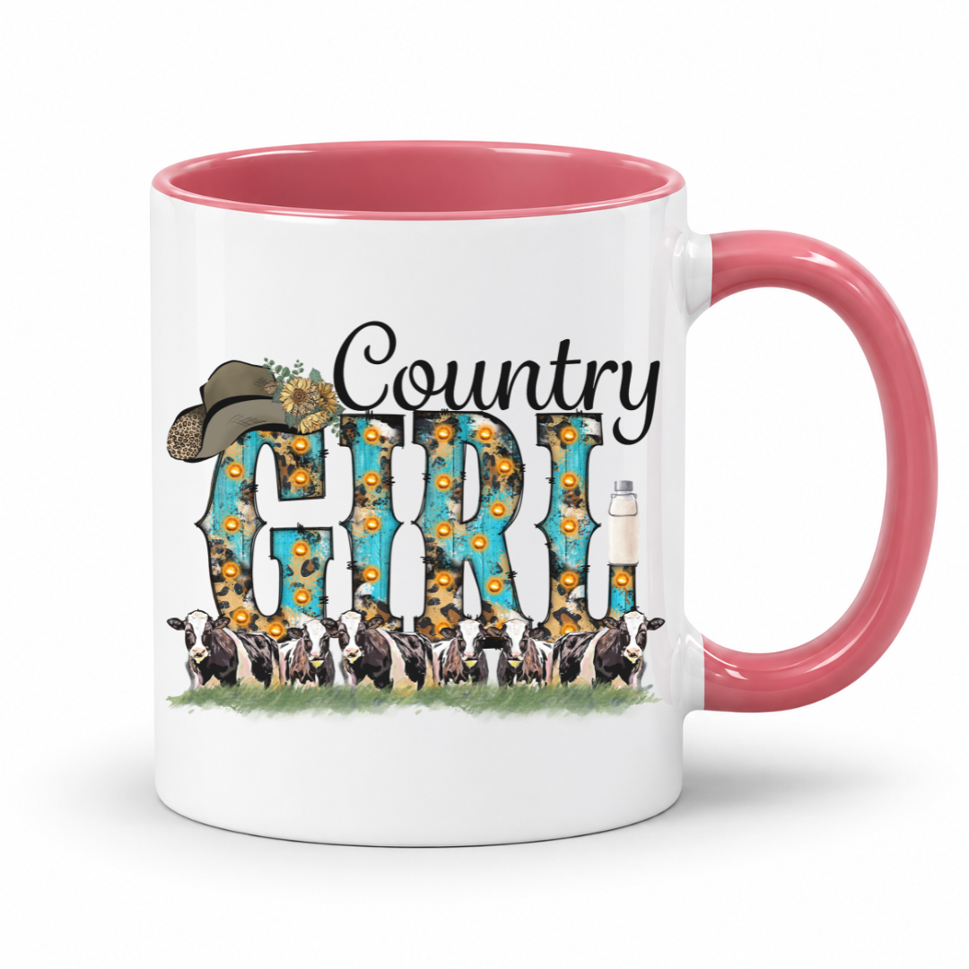 A white ceramic coffee mug with a pink interior and handle, featuring a 'Country Girl' graphic with sunflowers, a cowboy hat, and dairy cows.  From Coffee and Moo NZ