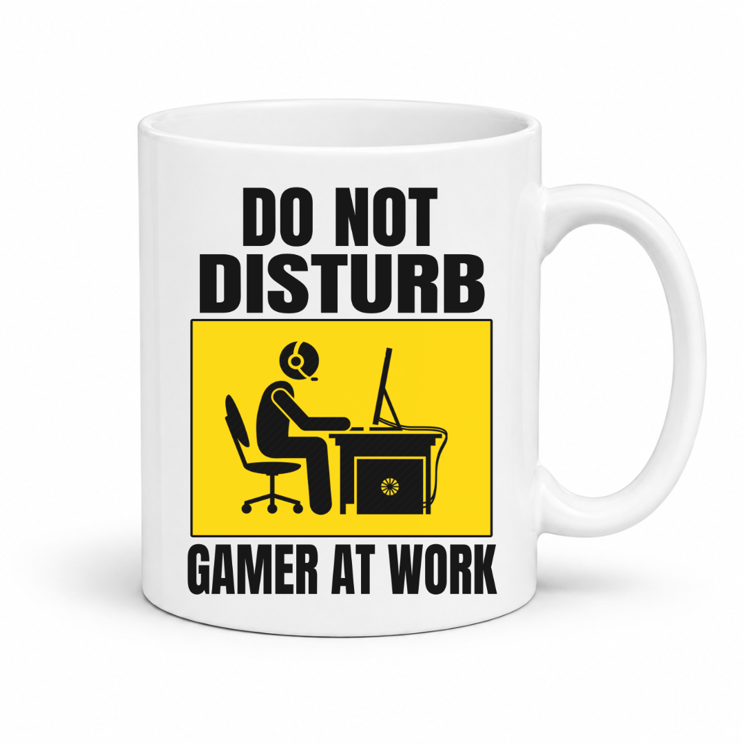 Do Not Disturb Gamer at Work gaming coffee mug featuring, bold black lettering and a yellow and black graphic of a gamer at a computer, from Coffee and Moo.
