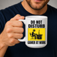 Male holding Do Not Disturb Gamer at Work gaming coffee mug, showcasing the bold warning-style design, by Coffee and Moo