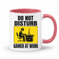 Do Not Disturb Gamer at Work gaming coffee mug featuring pink inner & handle, bold black lettering and a yellow and black graphic of a gamer at a computer, from Coffee and Moo.