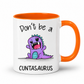 A white ceramic mug with a bright orange handle and interior, featuring a cartoon purple dinosaur graphic and the text 'Don't be a CUNTASaurus' printed on the front. Grab yours from Coffee and Moo NZ.