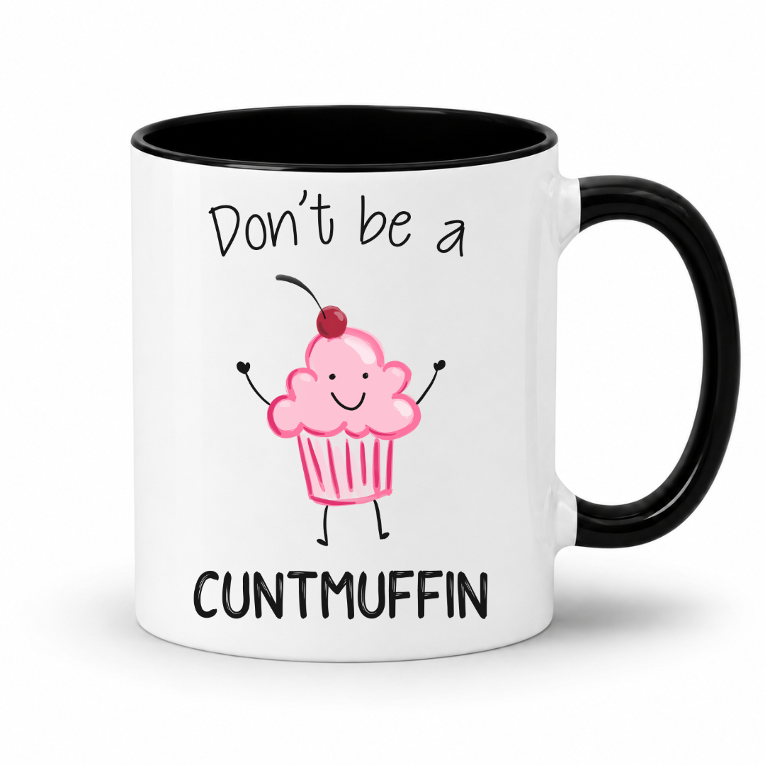 A white ceramic mug with a black handle and black interior, printed with the phrase 'Don't be a CUNTMUFFIN' in black text around a cute pink cupcake illustration with a cherry on top. Grab yours from Coffee and Moo NZ.