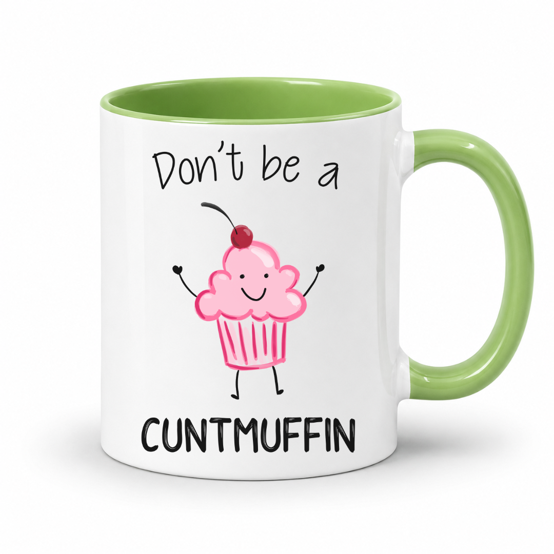 A white ceramic mug with a light green handle and interior, featuring a cute cartoon cupcake with a cherry on top and the text 'Don't be a CUNTMUFFIN' printed in black. Grab yours from Coffee and Moo NZ.