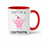 A white ceramic mug with a red interior and red handle, featuring a cute pink cupcake graphic and the text 'Don't be a CUNTMUFFIN' in black lettering. Grab yours from Coffee and Moo NZ.