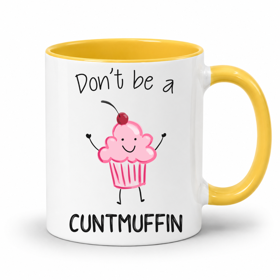 A white ceramic mug with a yellow interior and yellow handle, featuring a cartoon pink cupcake with a cherry and the text 'Don't be a CUNTMUFFIN' on the front. Grab yours from Coffee and Moo NZ.