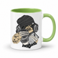 A white ceramic coffee mug with a green interior and green handle,  featuring a cartoon illustration of a sloth wearing a black knit beanie, over-ear headphones, and holding a cup with the word 'TEARS' on it and a diary, shown against a plain white background. Grab yours from Coffee and Moo NZ.