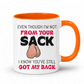 A white ceramic mug with a orange interior and handle, featuring a humorous graphic with the text 'EVEN THOUGH I'M NOT FROM YOUR SACK I KNOW YOU'VE STILL GOT MY BACK' and a cartoon drawing of hairy balls. Grab yours from Coffee and Moo NZ.