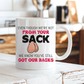 A white ceramic coffee mug with a  humorous graphic. The mug features the text 'EVEN THOUGH WE'RE NOT FROM YOUR SACK WE KNOW YOU'VE STILL GOT OUR BACKS' in black and red lettering, accompanied by a cartoon drawing of a hairy balls. Grab your mug from Coffee and Moo NZ.