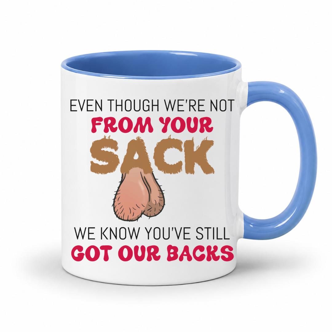 A white ceramic coffee mug with a blue interior and handle, has a humorous graphic. The mug features the text 'EVEN THOUGH WE'RE NOT FROM YOUR SACK WE KNOW YOU'VE STILL GOT OUR BACKS' in brown and red lettering, accompanied by a cartoon drawing of a hairy balls. Grab your mug from Coffee and Moo NZ.