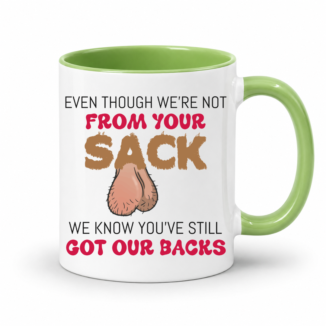 A white ceramic coffee mug with a green interior and handle, has a humorous graphic. The mug features the text 'EVEN THOUGH WE'RE NOT FROM YOUR SACK WE KNOW YOU'VE STILL GOT OUR BACKS' in brown and red lettering, accompanied by a cartoon drawing of a hairy balls. Grab your mug from Coffee and Moo NZ.
