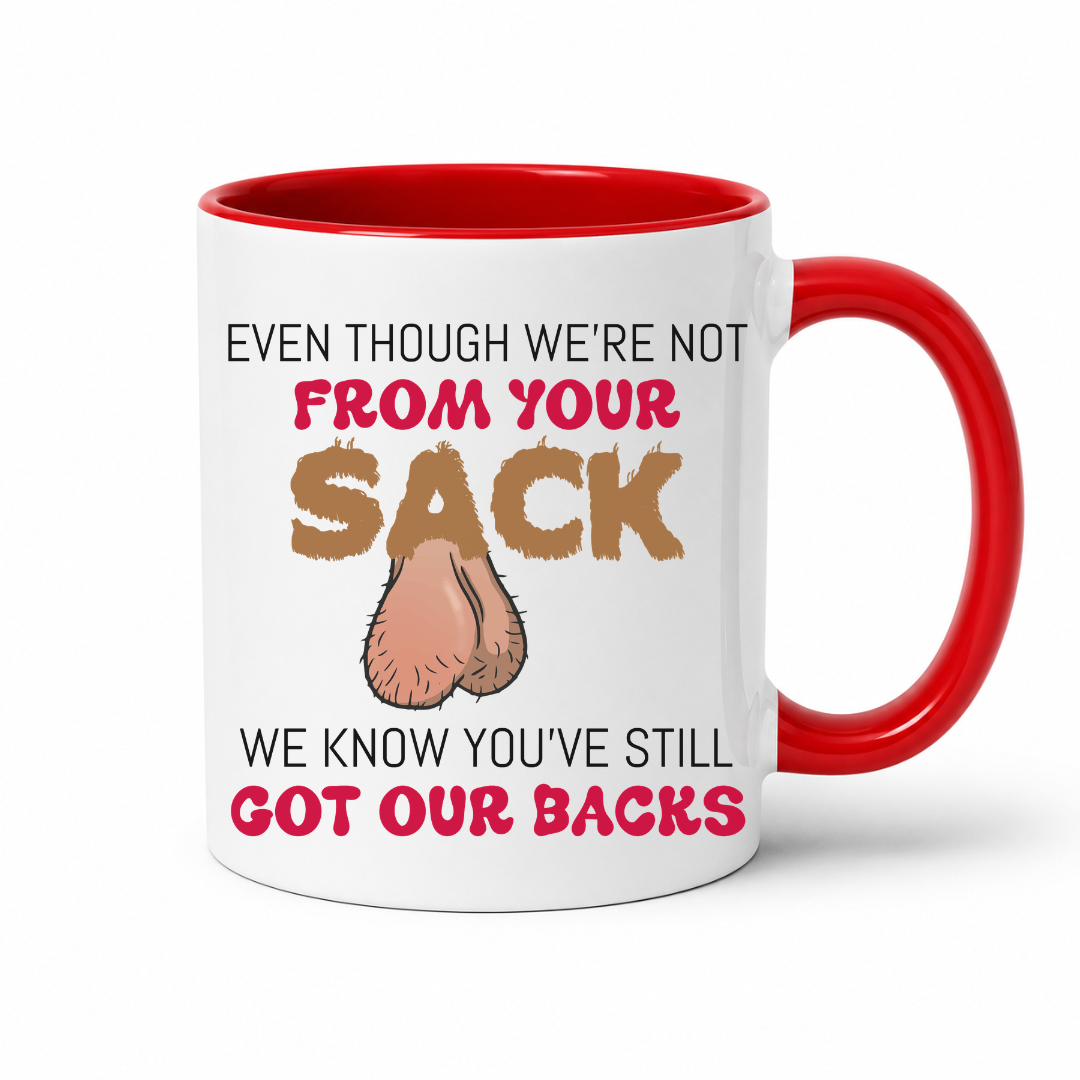 A white ceramic coffee mug with a red interior and handle, has a humorous graphic. The mug features the text 'EVEN THOUGH WE'RE NOT FROM YOUR SACK WE KNOW YOU'VE STILL GOT OUR BACKS' in brown and red lettering, accompanied by a cartoon drawing of a hairy balls. Grab your mug from Coffee and Moo NZ.