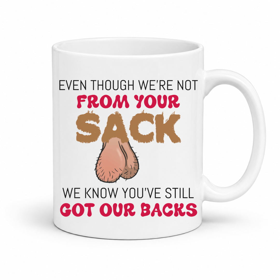 A white ceramic coffee mug with a  has a humorous graphic. The mug features the text 'EVEN THOUGH WE'RE NOT FROM YOUR SACK WE KNOW YOU'VE STILL GOT OUR BACKS' in brown and red lettering, accompanied by a cartoon drawing of a hairy balls. Grab your mug from Coffee and Moo NZ.