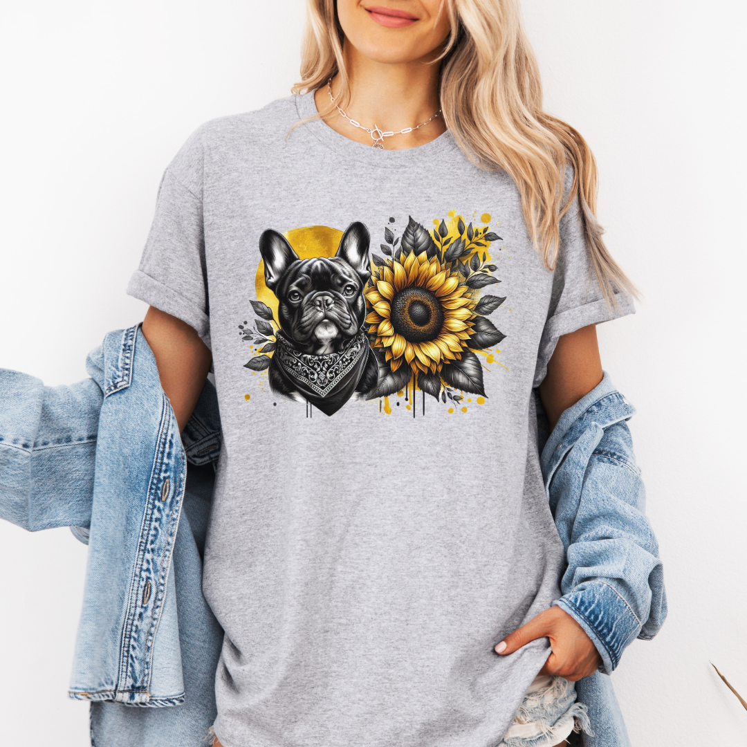 A woman wearing a grey graphic t-shirt with a French Bulldog and sunflower print, styled with a light blue denim jacket draped off her shoulders. Grab your tee from Coffee and Moo NZ.