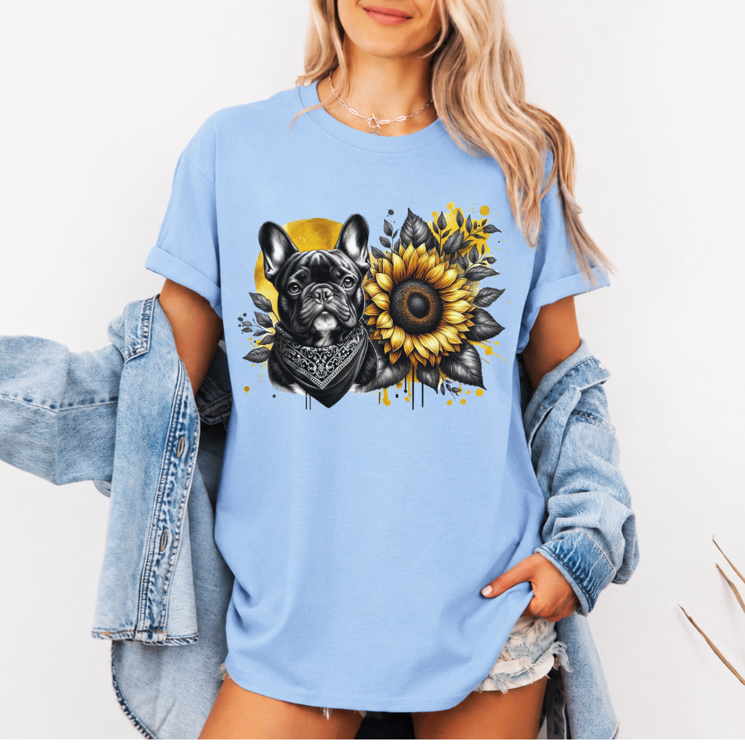 A woman wearing an oversized baby blue graphic t-shirt with a French Bulldog and sunflower print, styled with a light blue denim jacket draped off her shoulders. Grab your tee from Coffee and Moo NZ.