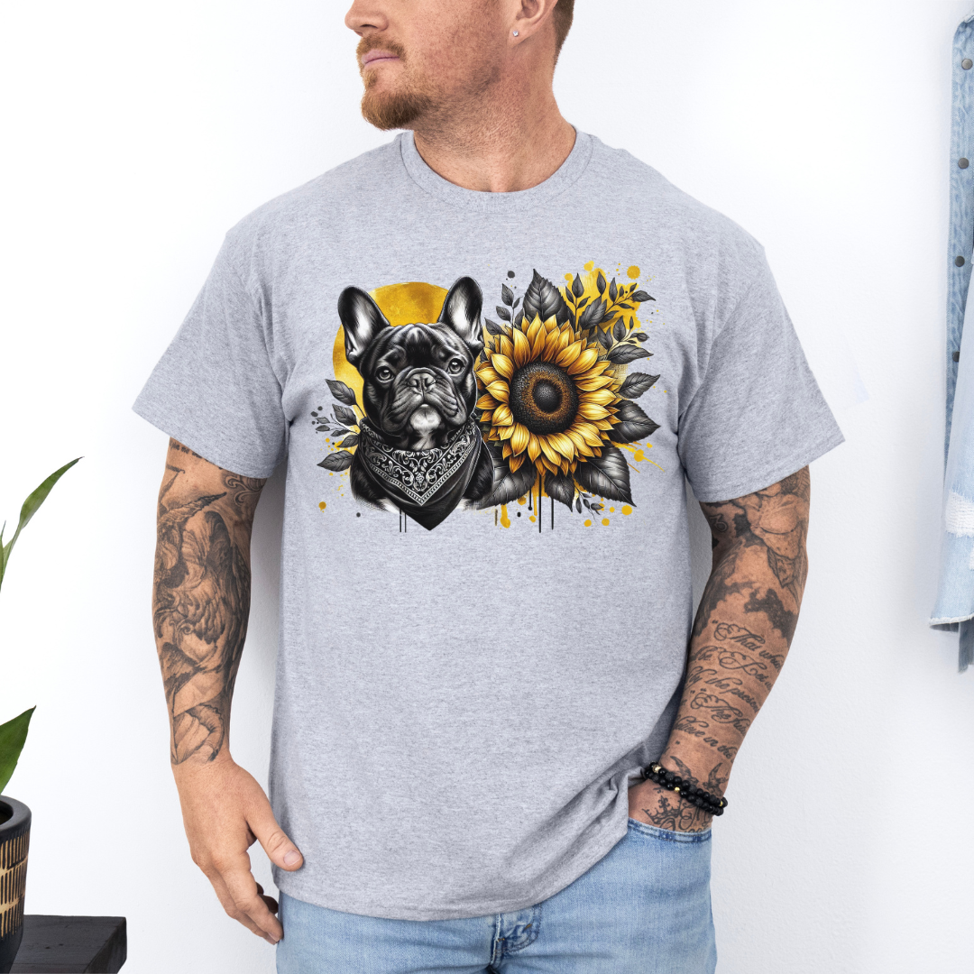 A man wearing a grey graphic t-shirt featuring a French Bulldog and a sunflower design, paired with light blue jeans against a white wall. Grab your tee from Coffee and Moo NZ.