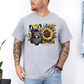 A man wearing a grey graphic t-shirt featuring a French Bulldog and a sunflower design, paired with light blue jeans against a white wall. Grab your tee from Coffee and Moo NZ.