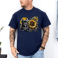 A man wearing a navy graphic t-shirt featuring a French Bulldog and a sunflower design, paired with light blue jeans against a white wall. Grab your tee from Coffee and Moo NZ.