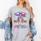 A woman wearing a grey graphic t-shirt with a colorful cartoon unicorn and bold profane text, "With a fuck fuck here… and a fuck fuck there… here a fuck, there a fuck… I don't give a fuck!", styled with an open light-wash denim jacket against a plain white background. From Coffee and Moo NZ