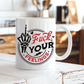 A white ceramic coffee mug with a bold graphic design, sitting on a rustic white wooden table in a warm, blurred kitchen setting. The graphic features a skeleton hand giving a middle finger in black, with the words 'Fuck YOUR FEELINGS' in red and black script. Purchase from Coffee and Moo NZ.