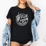A woman wearing an oversized black graphic T-shirt with a white circular design featuring a skeleton hand gesture and the text 'Fuck Your Feelings,' styled with an open light-wash denim jacket and denim shorts against a plain white background. Purchase from Coffee and Moo NZ.