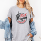 A woman wearing a heather gray graphic t-shirt with a black and red 'Fuck Your Feelings' design, styled with an open light blue denim jacket against a plain white background. Purchase from Coffee and Moo NZ.