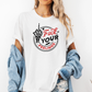 A woman wearing a white graphic t-shirt with a black and red circular design that reads 'Fuck Your Feelings' with a skeletal hand gesture, styled with an off-the-shoulder light blue denim shirt and ripped jeans against a plain white background. Purchase from Coffee and Moo NZ.