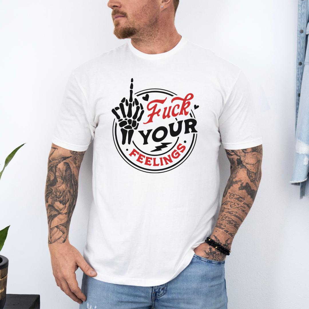 A man wearing a white graphic t-shirt with a black and red circular design that reads 'Fuck YOUR FEELINGS' with a skeletal hand gesture, paired with blue jeans. purchase yours from Coffee and Moo NZ.