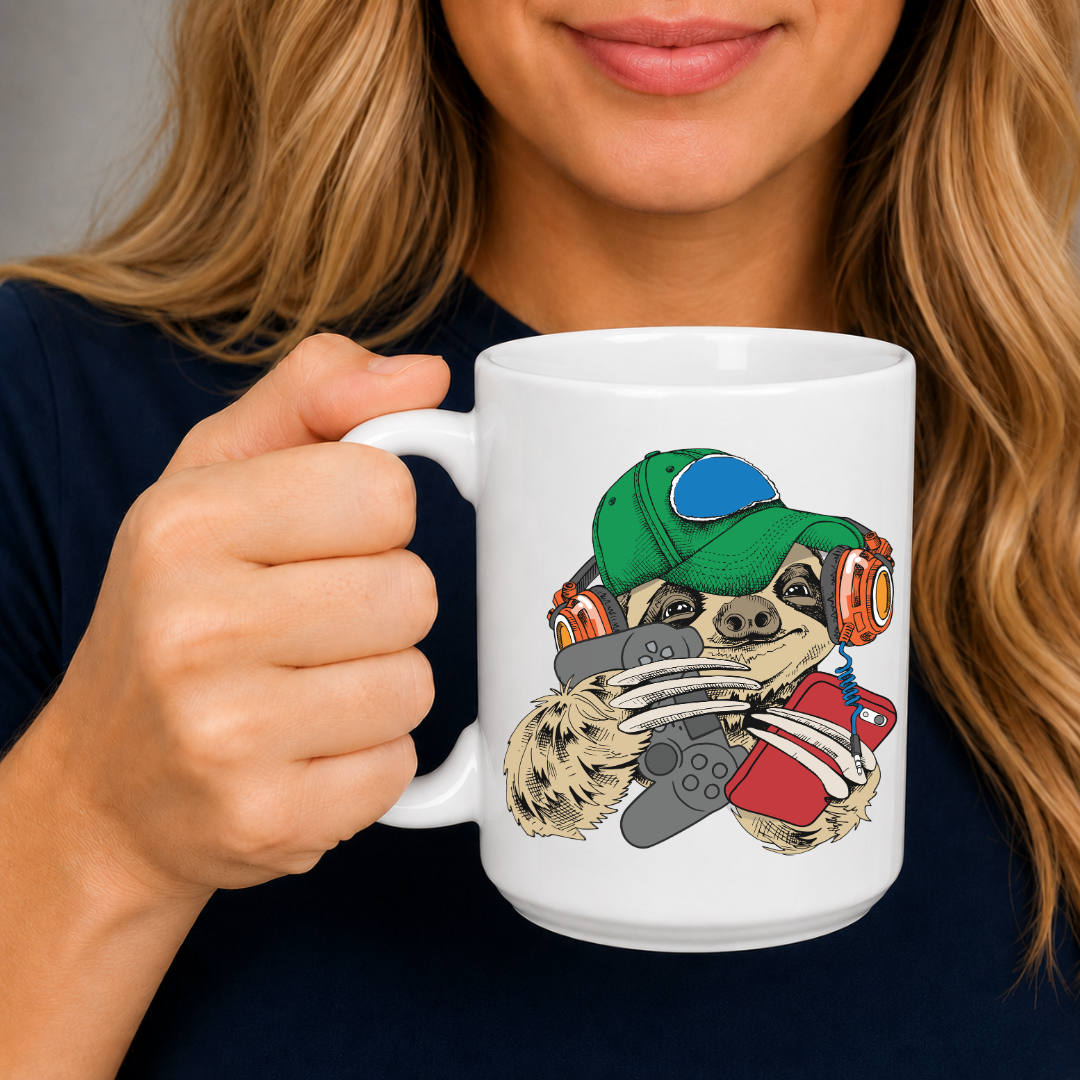 A woman holding a white ceramic mug with a colorful cartoon sloth graphic wearing a green cap and holding a game controller. The person is wearing a dark navy shirt against a neutral gray background. Purchase your mug from Coffee and Moo NZ.