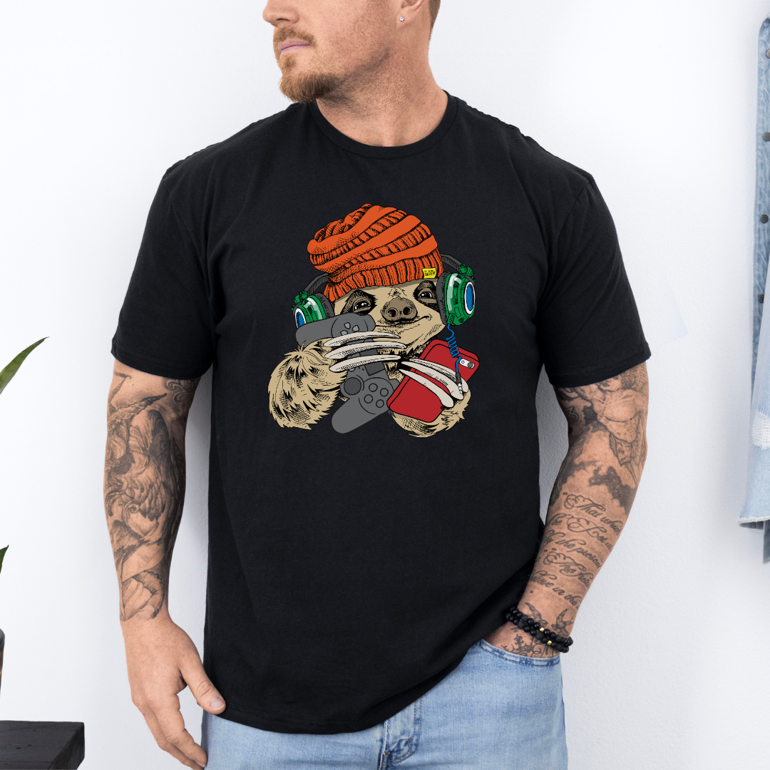 Male wearing a black graphic T-shirt  featuring a colorful cartoon sloth wearing an orange knit beanie, green headphones, while holding a red phone and grey controller. Grab your tee from Coffee and Moo NZ.