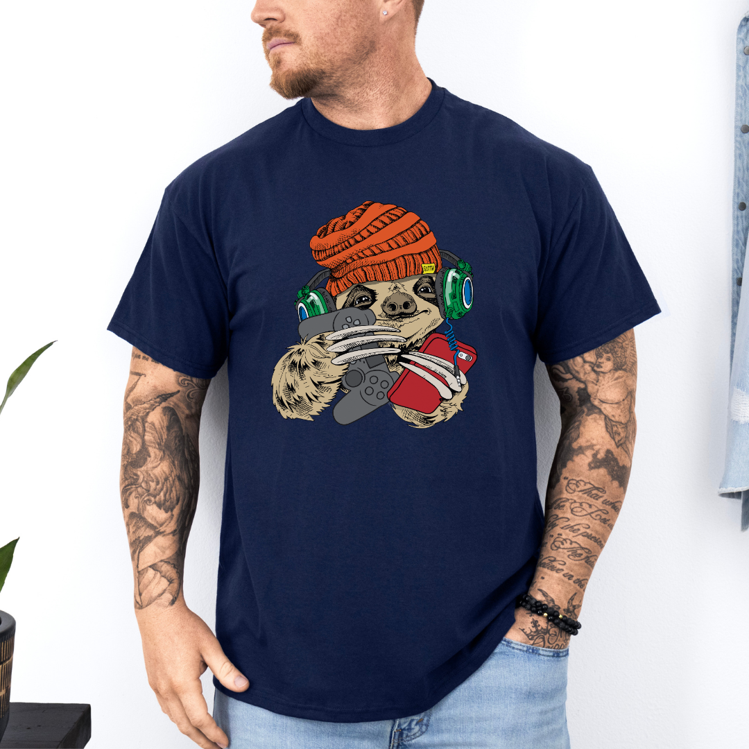Male wearing a navy blue graphic T-shirt  featuring a colorful cartoon sloth wearing an orange knit beanie, green headphones, while holding a red phone and grey controller. Grab your tee from Coffee and Moo NZ.